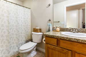 Bathroom featuring tile patterned floors, toilet, vanity, and walk in shower