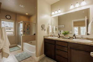 Bathroom with dual vanity, independent shower and bath, and tile flooring