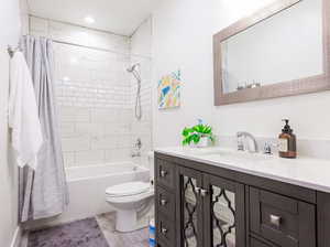 Full bathroom featuring vanity, toilet, and large shower / bath combo