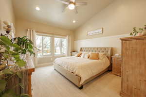 Bedroom featuring ceiling fan, lofted ceiling, and light carpet