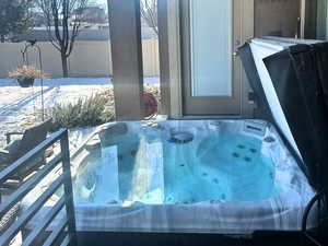 Snow covered patio with a hot tub