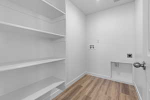 Washroom featuring hardwood / wood-style flooring, electric dryer hookup, and washer hookup