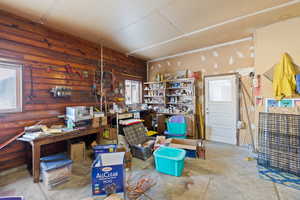 Interior space with concrete flooring, wooden walls, and a workshop area