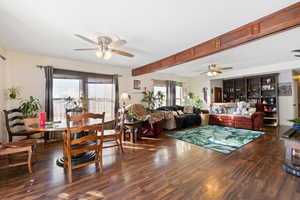 Living room with ceiling fan and dark hardwood / wood-style flooring