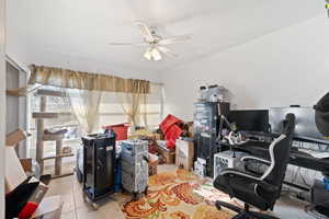 Home office with light tile patterned flooring and ceiling fan