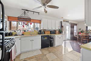 Kitchen featuring white cabinetry, sink, plenty of natural light, and black appliances