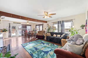 Living room with french doors, ceiling fan, wood-type flooring, and beamed ceiling