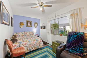 Bedroom with a textured ceiling and ceiling fan