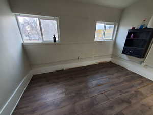 Unfurnished room with a healthy amount of sunlight and dark hardwood / wood-style floors