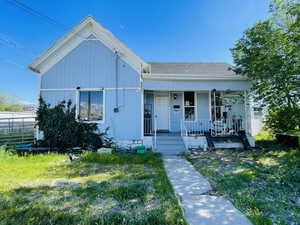 View of front of house with covered porch and roof with shingles