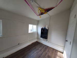 Spare room with dark hardwood / wood-style flooring