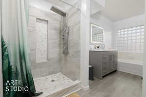 Bathroom with vanity, wood-type flooring, and plus walk in shower