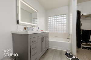 Bathroom with hardwood / wood-style flooring, vanity, and a bath