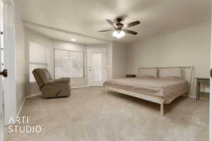 Carpeted bedroom with a textured ceiling and ceiling fan