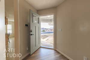 Foyer featuring a textured ceiling and light hardwood / wood-style flooring