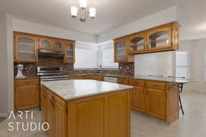 Kitchen with a chandelier, decorative light fixtures, a center island, and sink