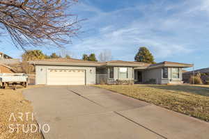 Ranch-style home featuring a garage and a front lawn