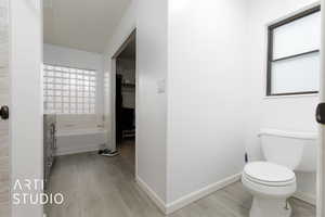 Bathroom featuring vanity, hardwood / wood-style floors, a tub, and toilet