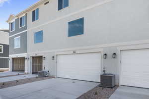 View of front of home featuring a garage and central air condition unit