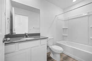 Full bathroom featuring shower / bathing tub combination, vanity, wood-type flooring, and toilet