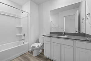 Full bathroom with vanity, wood-type flooring,  shower combination, and toilet