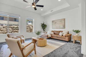 Carpeted living room with ceiling fan