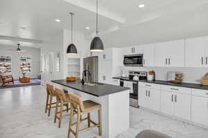 Kitchen with pendant lighting, sink, a kitchen bar, a kitchen island with sink, and stainless steel appliances