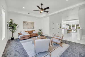 Carpeted living room with ceiling fan