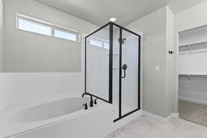Bathroom with a spacious closet, a shower stall, a bath, and marble finish floor