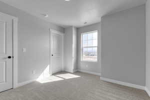 Unfurnished bedroom featuring visible vents, carpet flooring, a textured ceiling, and baseboards