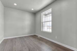 Spare room featuring recessed lighting, baseboards, and wood finished floors