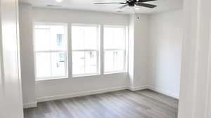 Empty room with ceiling fan and light hardwood / wood-style floors