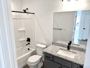 Full bathroom featuring shower / bath combination, vanity, wood-type flooring, and toilet