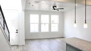 Unfurnished living room with ceiling fan and light hardwood / wood-style floors