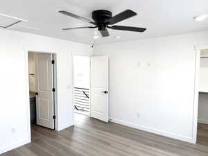 Unfurnished bedroom featuring hardwood / wood-style floors and ceiling fan