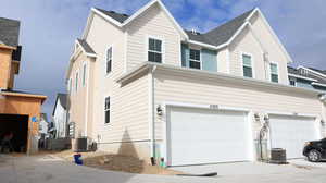 View of home's exterior with a garage and cooling unit