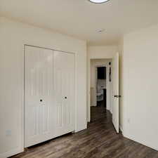 Unfurnished bedroom with dark wood-type flooring and a closet