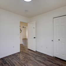 Unfurnished bedroom featuring dark wood-type flooring