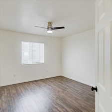 Unfurnished room with ceiling fan and dark hardwood / wood-style flooring