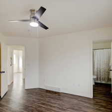 Master bedroom featuring dark wood-type flooring and ceiling fan