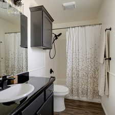 Full bathroom featuring vanity, toilet, hardwood / wood-style floors, and shower / bath combo