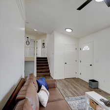 Living room with ceiling fan, lofted ceiling, and hardwood / wood-style floors