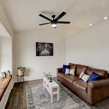 Living room with ceiling fan and dark hardwood / wood-style flooring