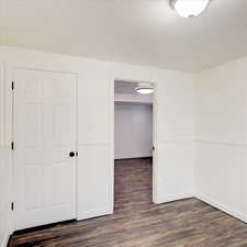 Unfurnished bedroom with dark wood-type flooring and a closet