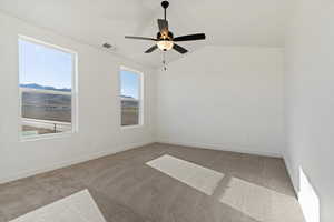 Unfurnished room featuring lofted ceiling, a mountain view, light carpet, and ceiling fan