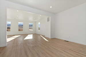 Empty room with a wealth of natural light and light wood-type flooring