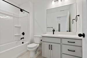 Full bathroom featuring tile patterned floors, shower / washtub combination, toilet, and vanity