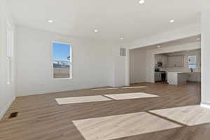 Unfurnished living room with sink and light hardwood / wood-style flooring