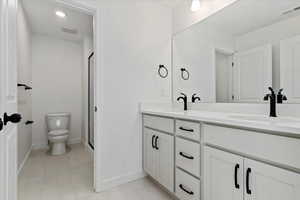 Bathroom with vanity, tile patterned flooring, a shower with shower door, and toilet