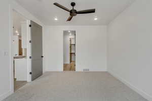 Unfurnished bedroom with light colored carpet and ceiling fan